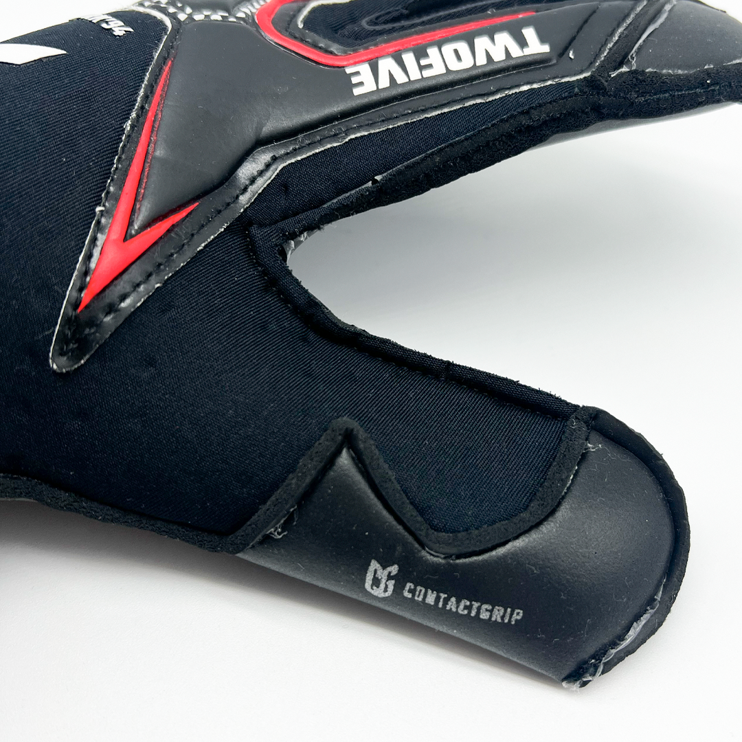 Close-up of black Guantes de Arquero New York '94 Contacgrip goalkeeper glove with red and white details on thumb area.